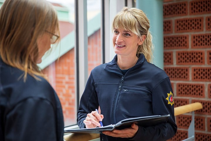 En person i blå uniform som för en dialog med en annan person 